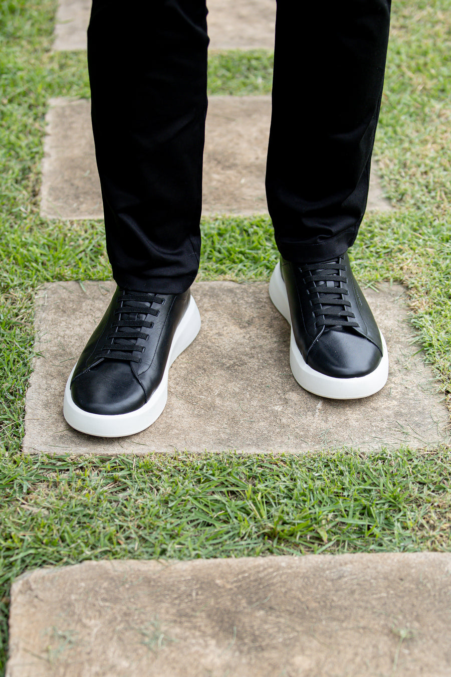 Tênis casual preto e branco da Casa Prado, com calça preta