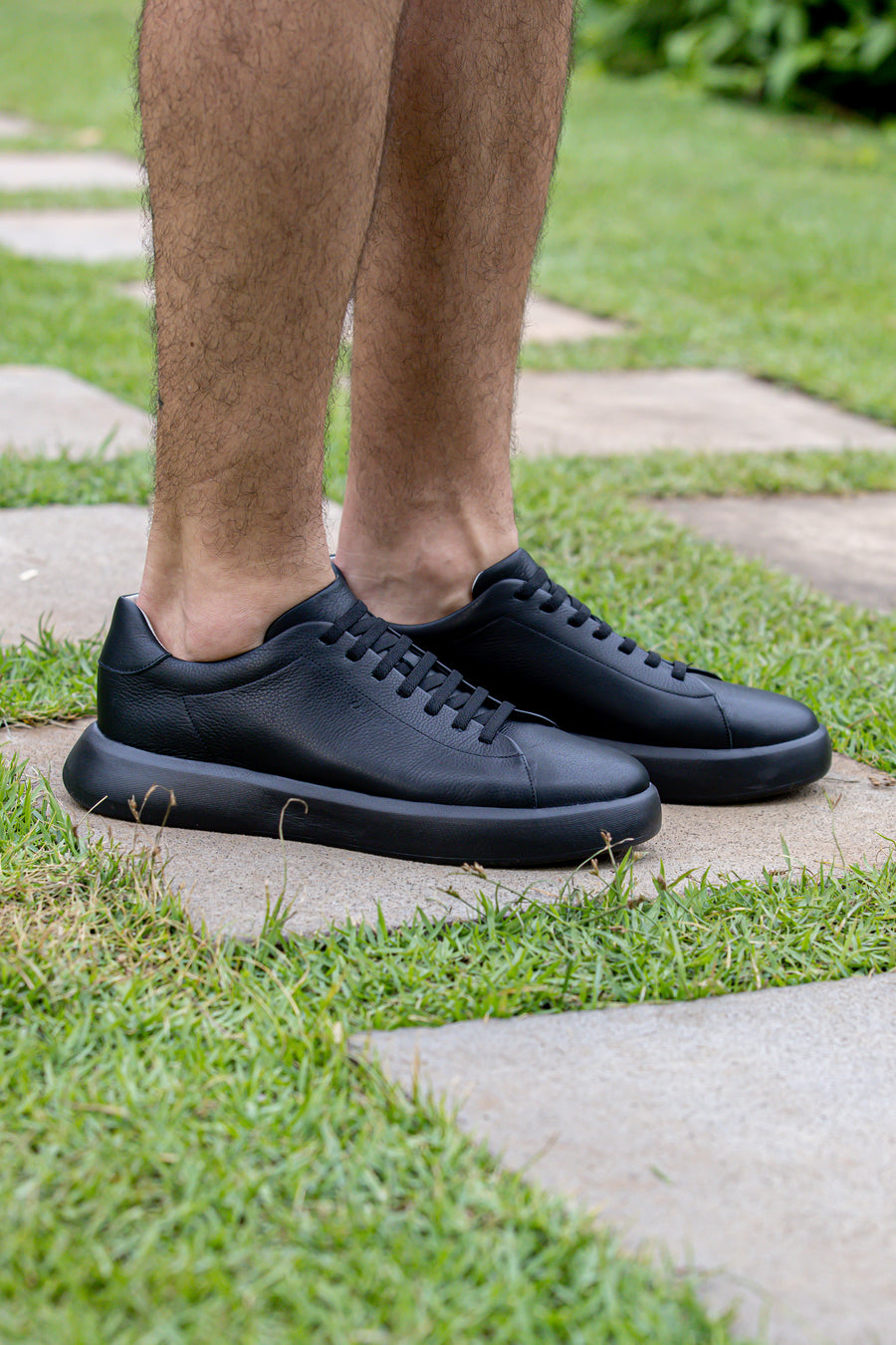 Tênis casual all black visto de lado, com solado preto